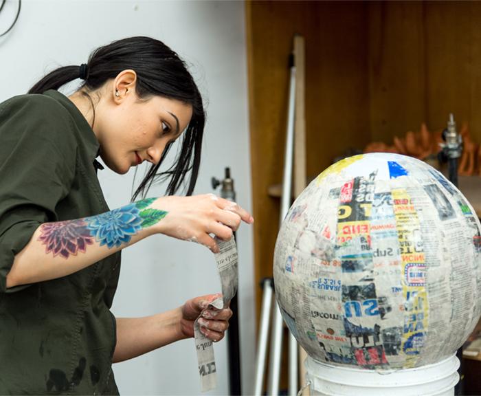 Image of a female art student creating a sculpture